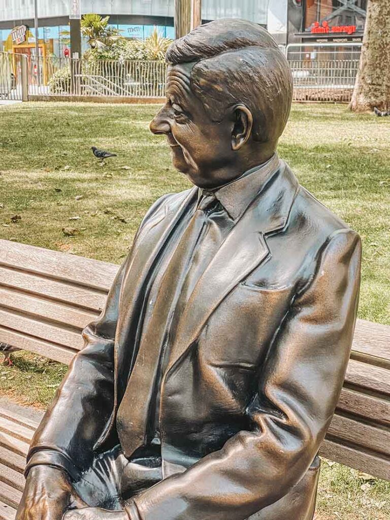 Mr Bean comic performer's bronze statue Rowan Atkinson sits happily in the gardens in Leicester square scenes in the square