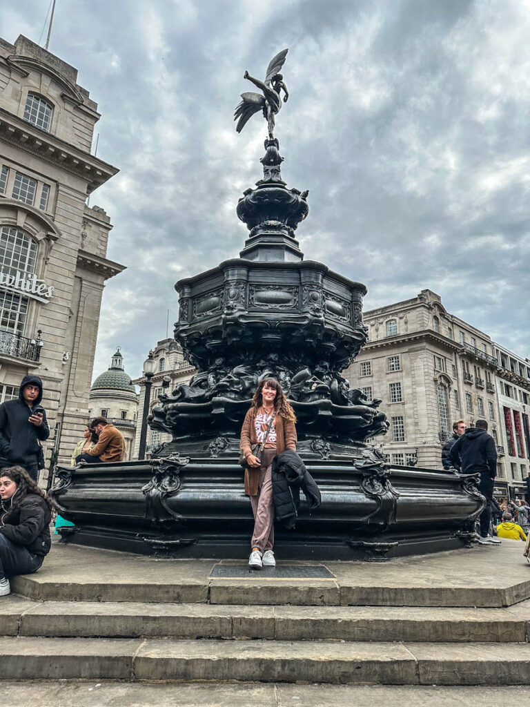 Eros Statue Piccadilly London with woman standing in front
